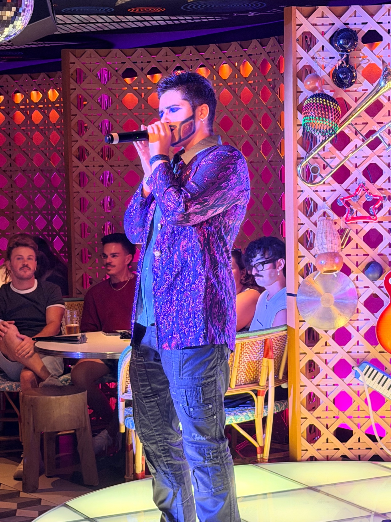 Artiste au micro en veste pailletée pendant la soirée
